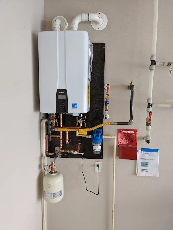 Professional plumber installing copper piping in a Pella home